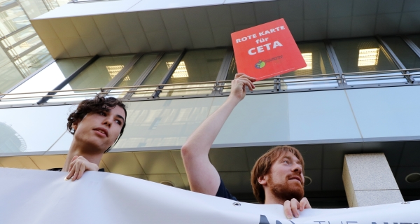Mit einer roten Karte protestiert ein Aktivist gegen CETA