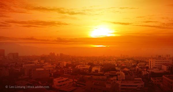 Blick auf eine Stadt schräg von oben in orangenem Licht.