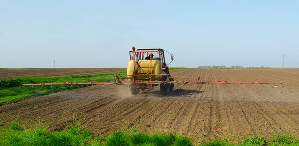 Ein Traktor bringt ein Herbizid aus